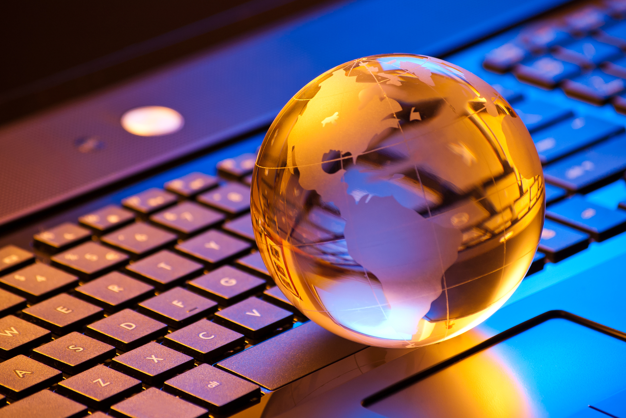 global computer business concept with small globe on laptop